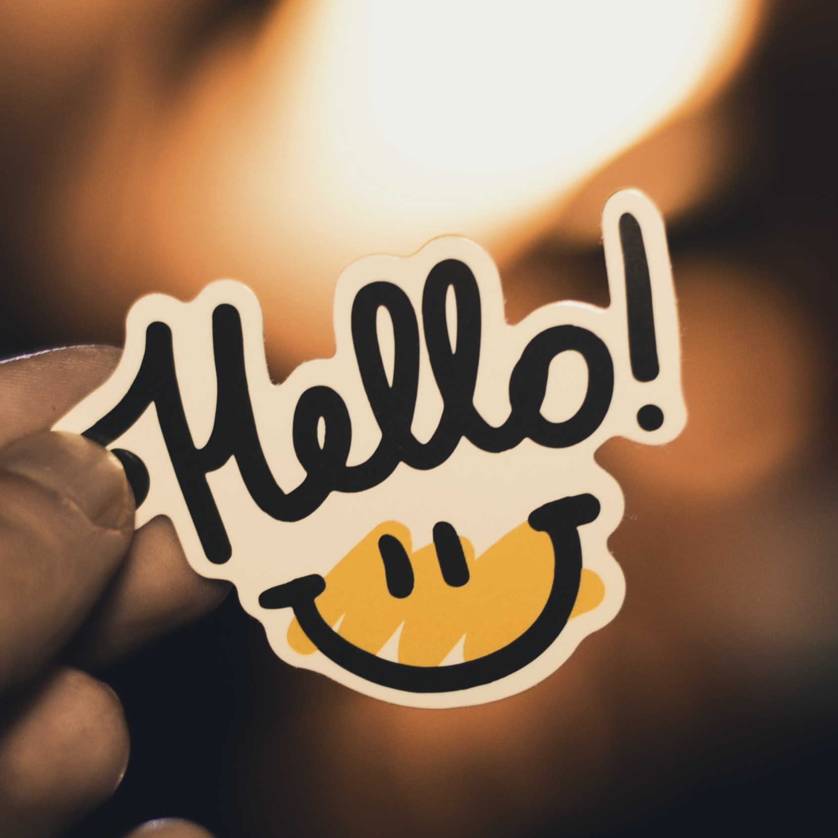 Foto: Ein Aufkleber mit "Hello"-Schrift und Smiley als Symbol für die Kontaktseite